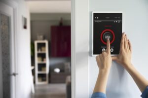 Persona controlando sistema domótico desde smartphone para gestionar luces y seguridad del hogar en Málaga